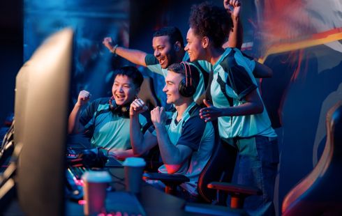 An e-sports team celebrating a win is pictured.