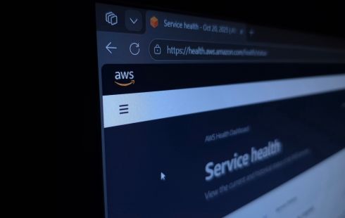 close-up photo of a computer screen displaying the AWS Service Health Dashboard webpage, showing the AWS logo and a browser tab labeled “Service health – Oct 20, 2025.”